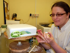 Talitha Crowe finishing a hand-decorated cake